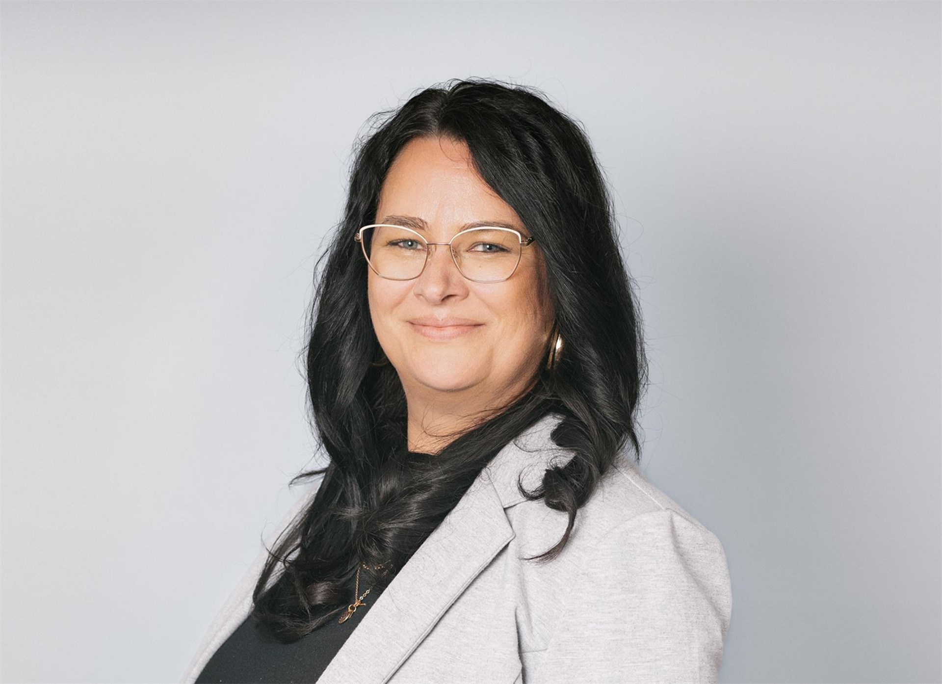 Portrait einer Frau mittleren Alters mit mittellangen dunklen Haaren und einem hellen Blazer